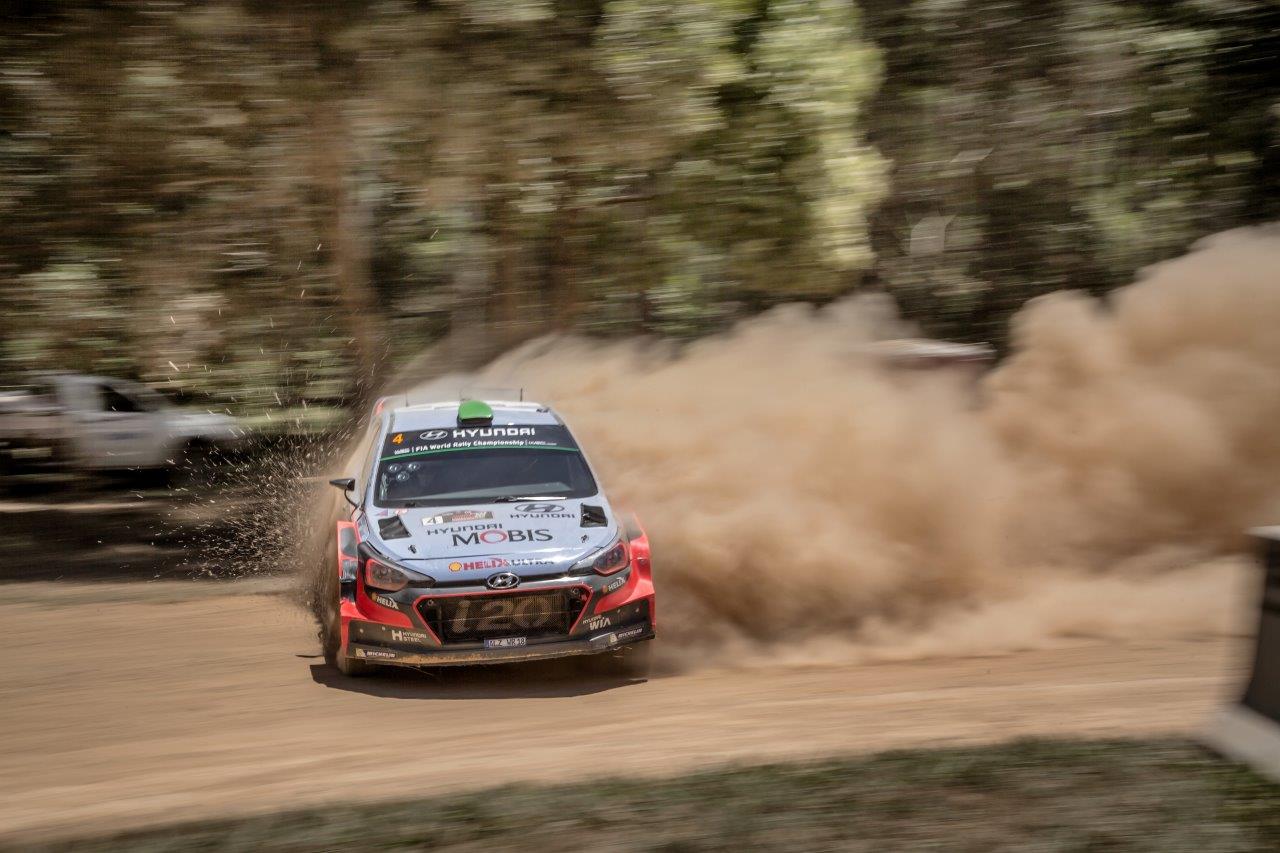 A WRC car kicking up dust on a rally stage